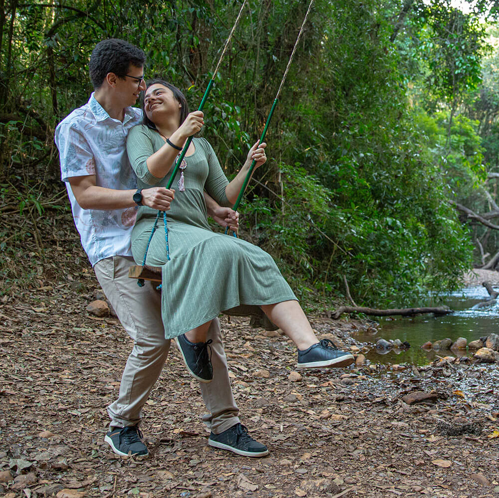 Artur e Kamila juntos em um balanço, em meio à natureza